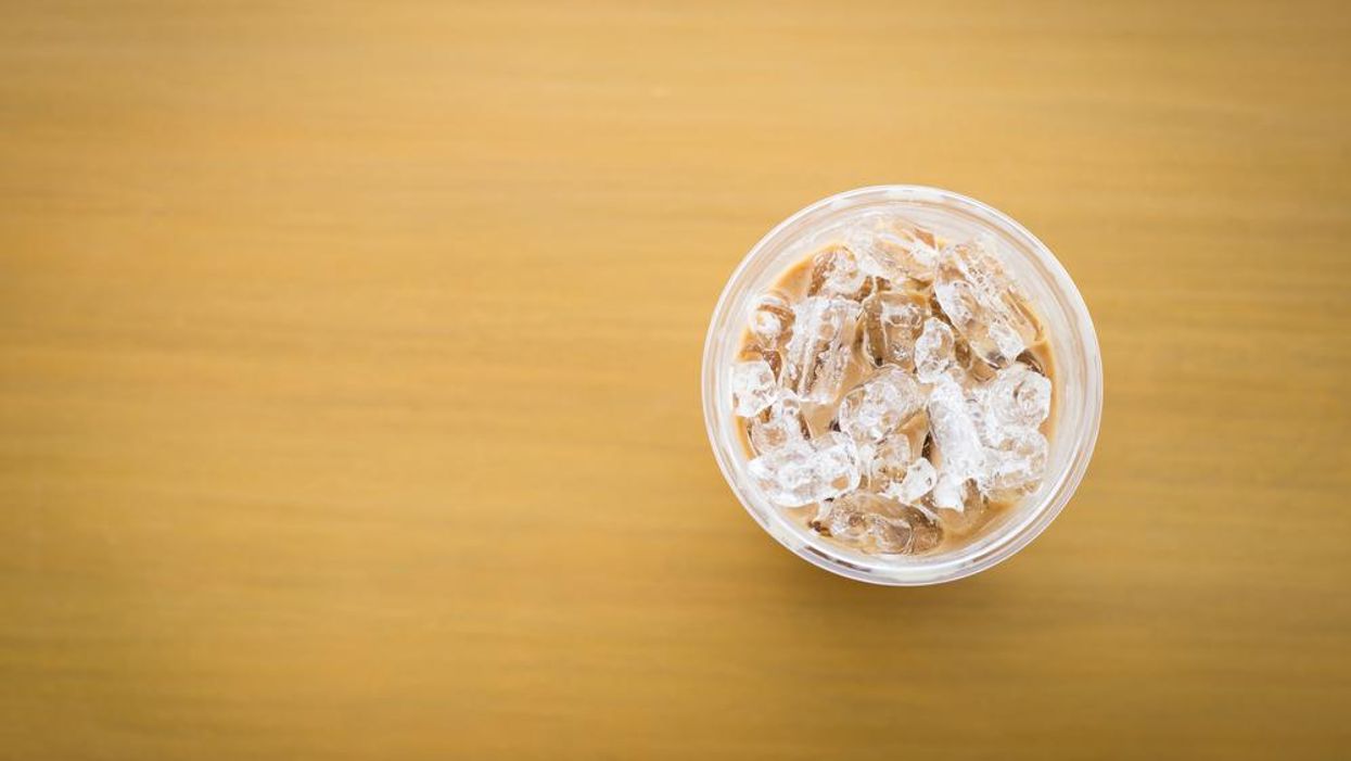 Cup of ice on brown background