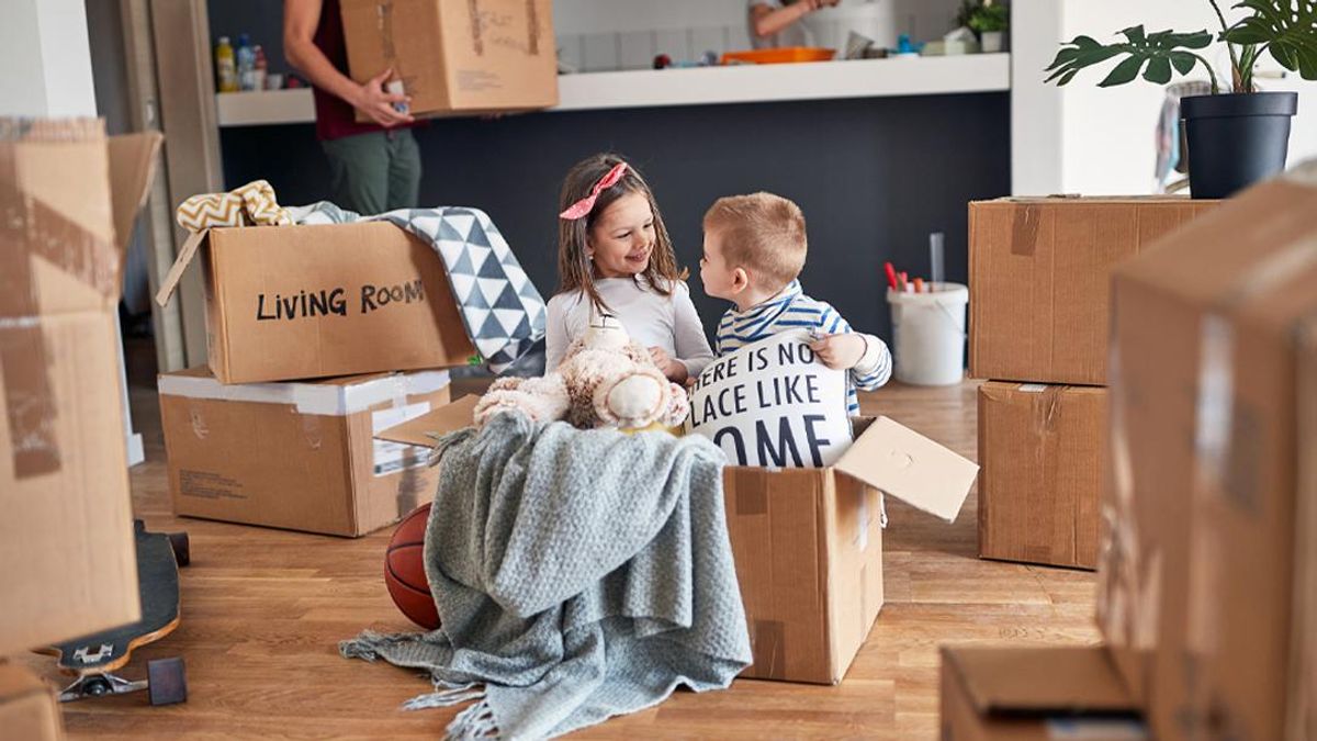 Kids look at home items packed into boxes.