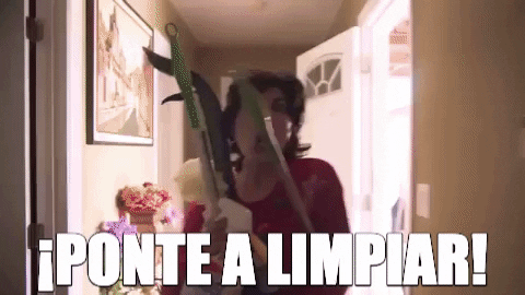 Woman walking down a hallway with cleaning supplies saying "ponte a limpiar"
