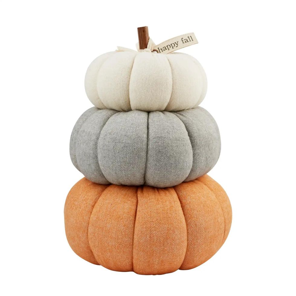 Three cloth pumpkins stacked on top of each other. Bottom is orange, middle is gray, top is right. Ribbon on top says "happy fall."