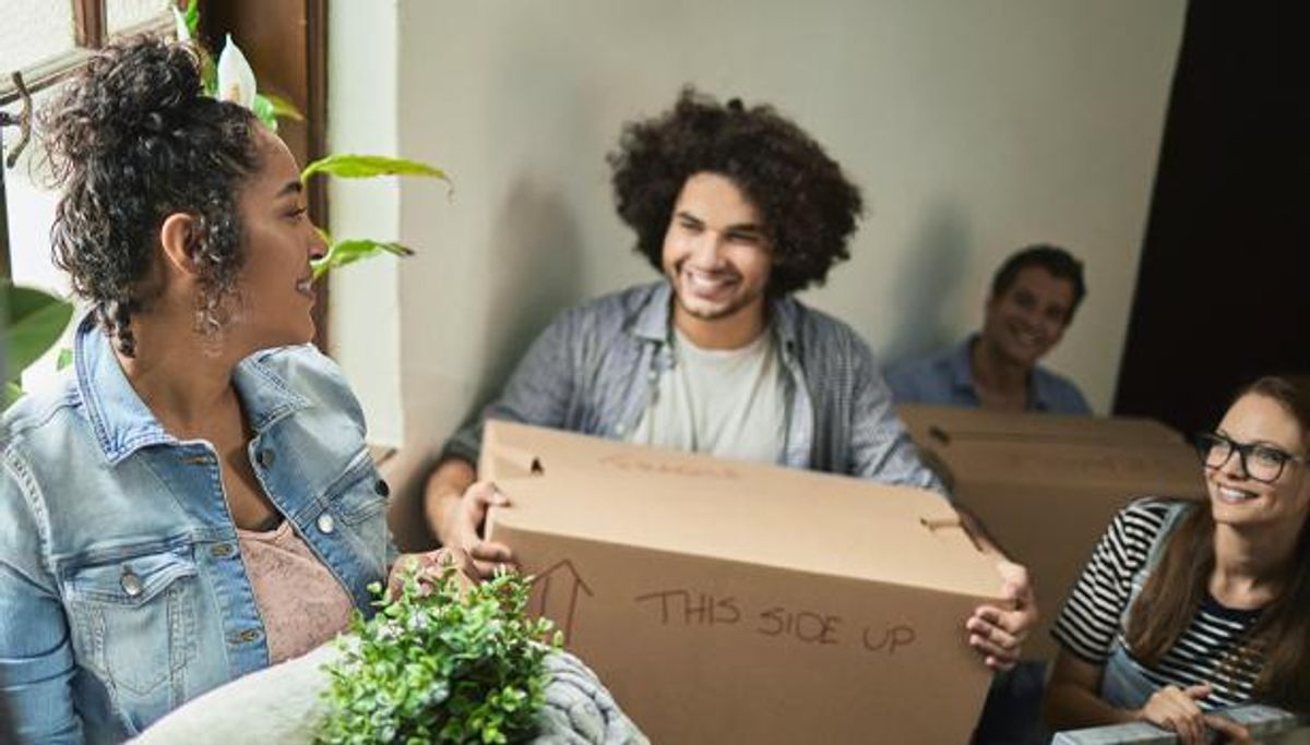 College students carry moving boxes.