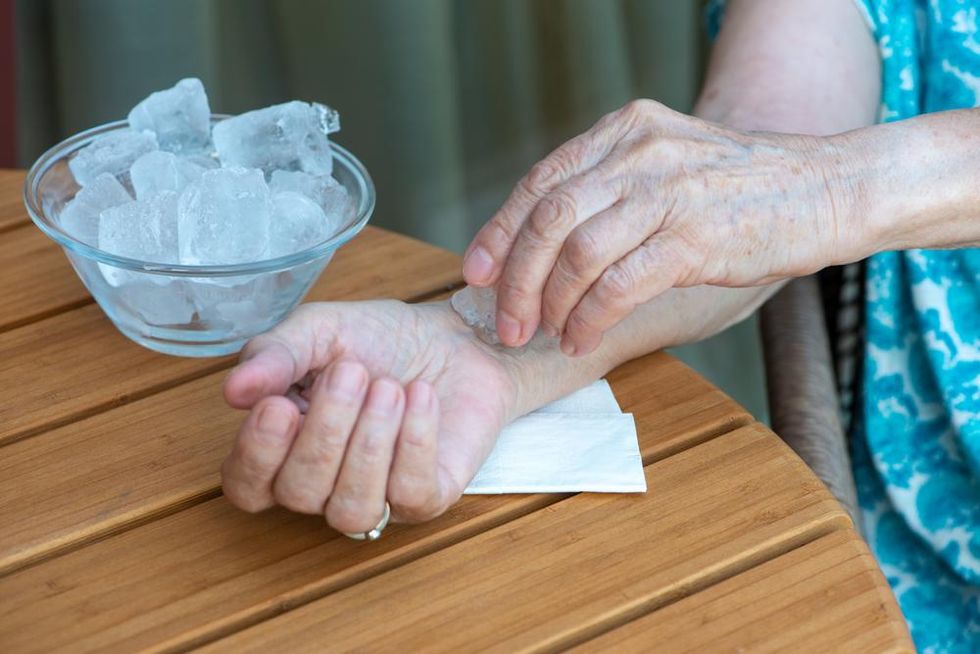 Woman presses ice to inside of wrist