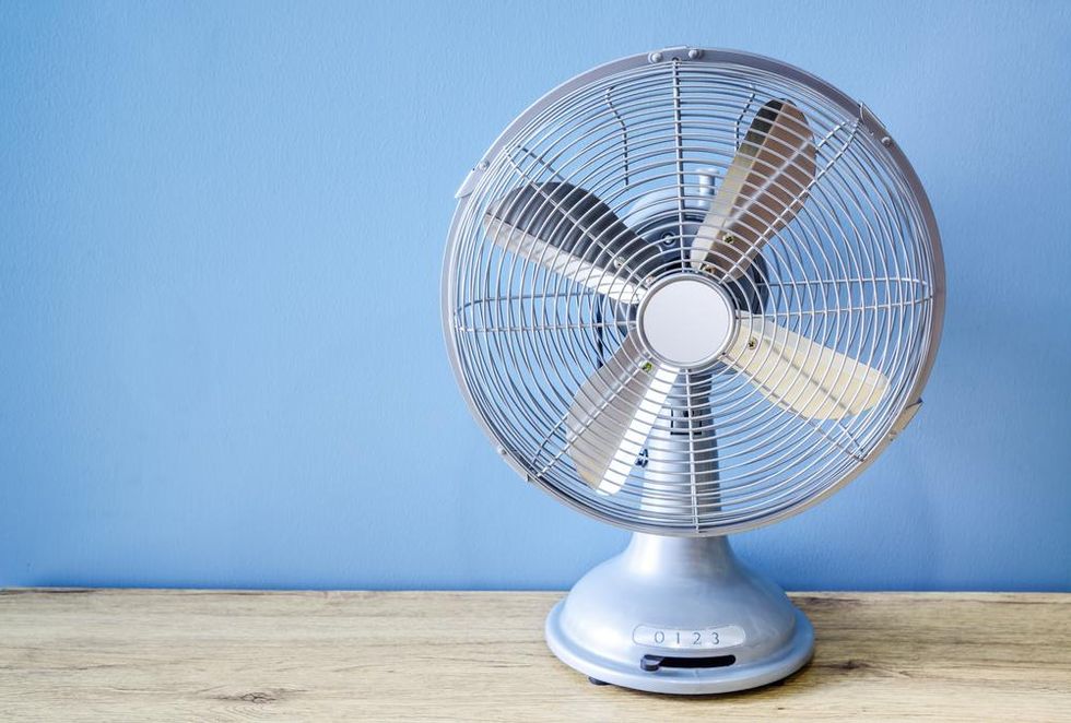 Baby blue fan in front of blue wall