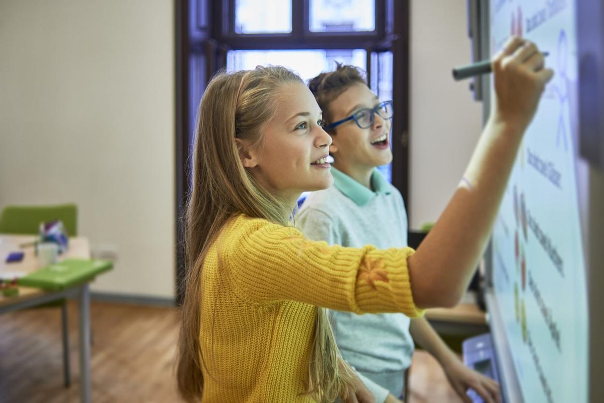 students using a smart whiteboard in a classroom