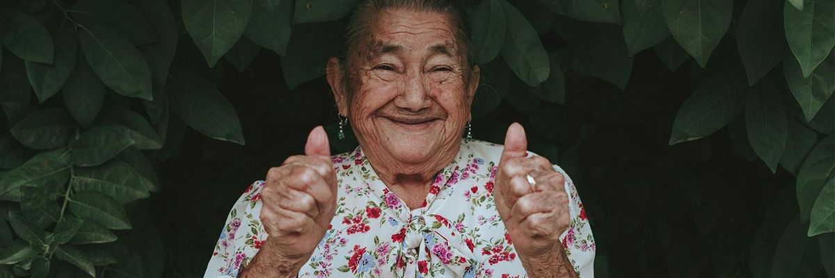 Latina grandma smiling at the camera while giving a thumbs up