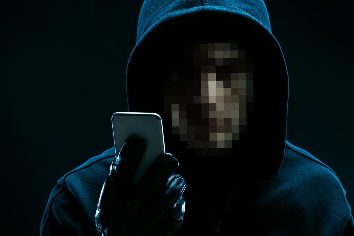 a photo of a hacker with a smartphone