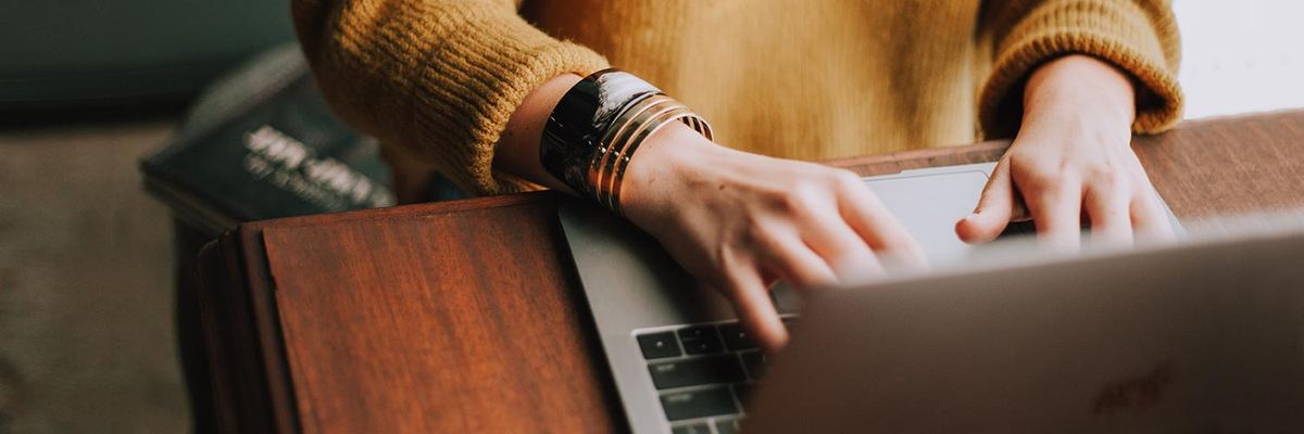 Close up of woman's hands as she types on a laptop computer