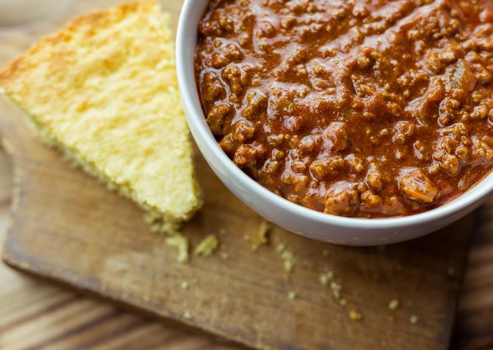 A bowl of Texas chili beside a piece of cornbread