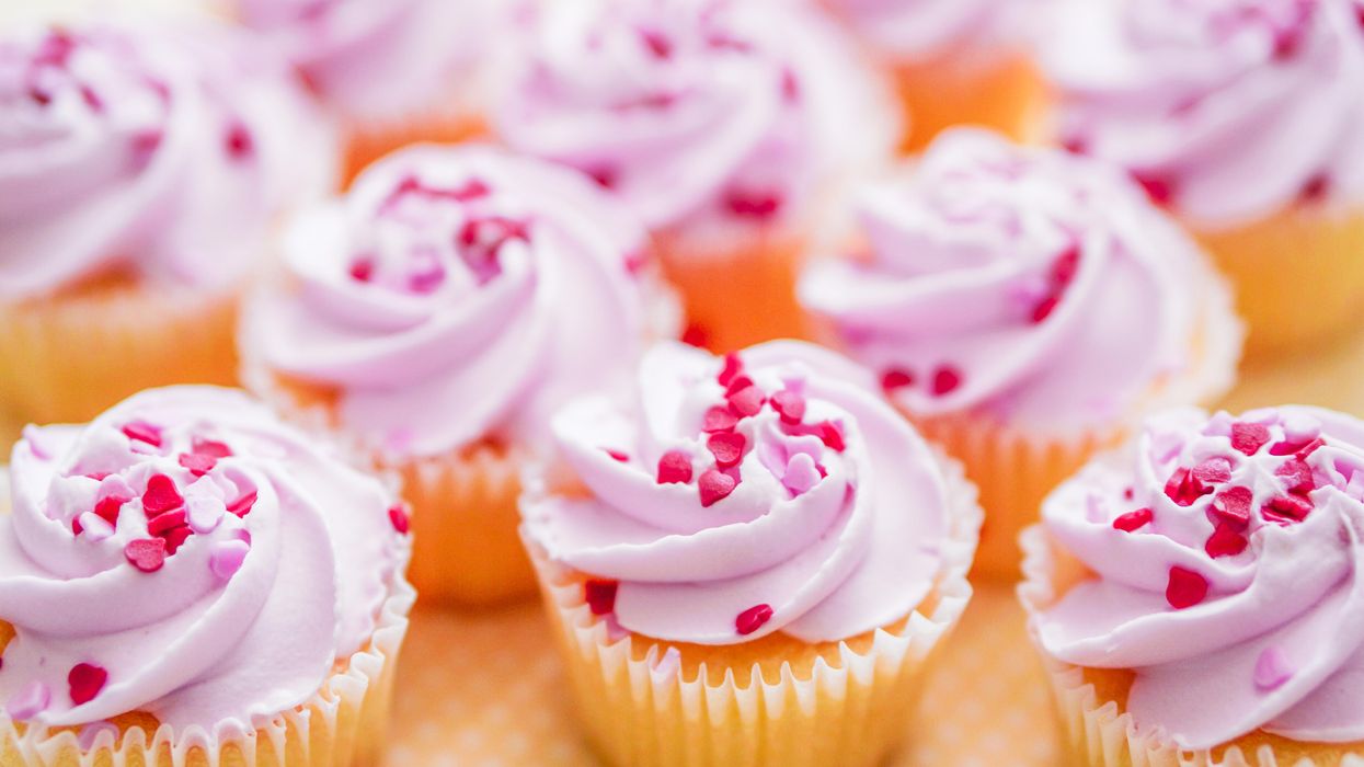 Vanilla cupcakes with light pink frosting and heart sprinkles