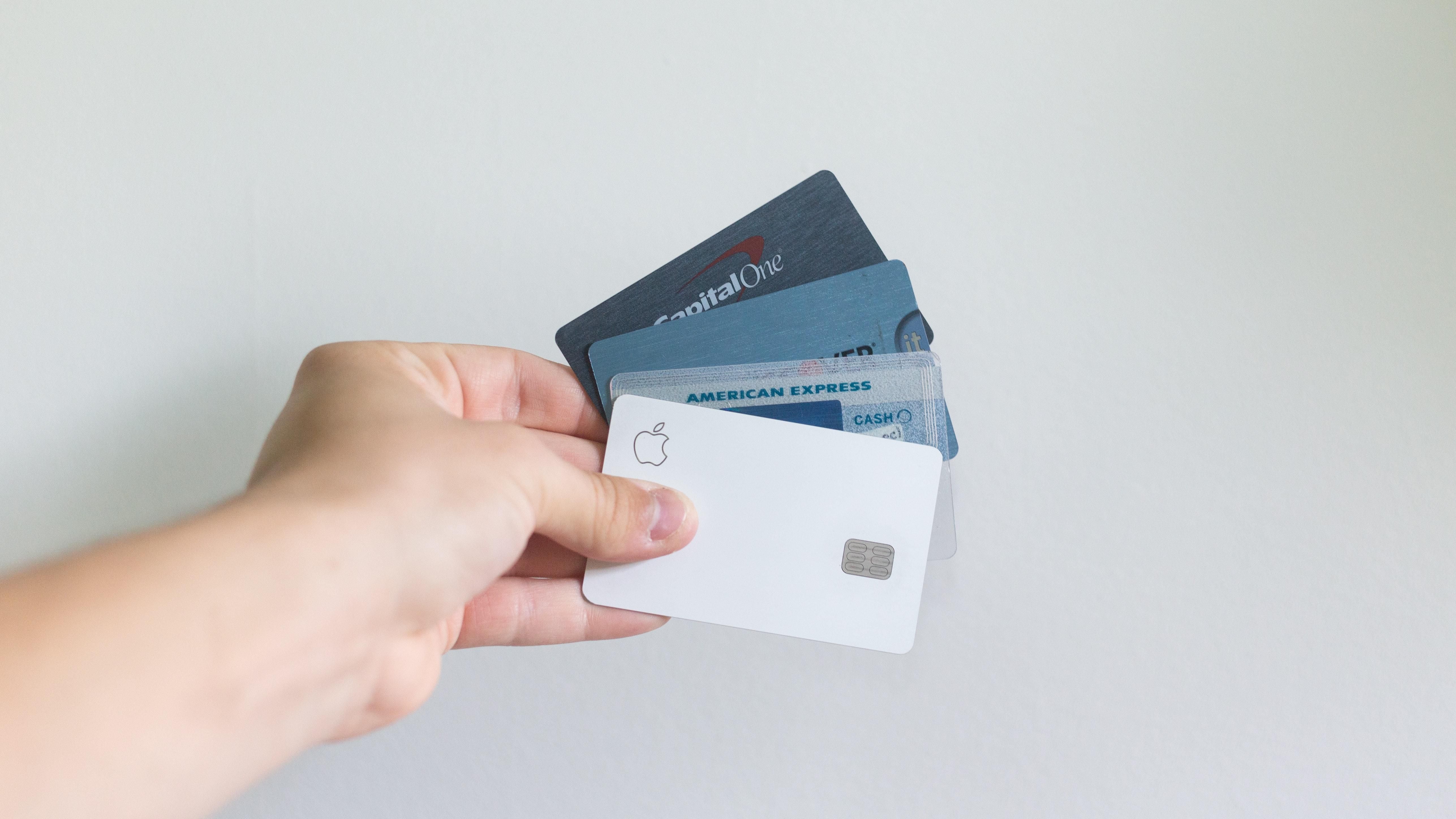 a person holding credit cards against a white background