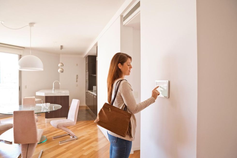 Photo of a woman activating a home security system