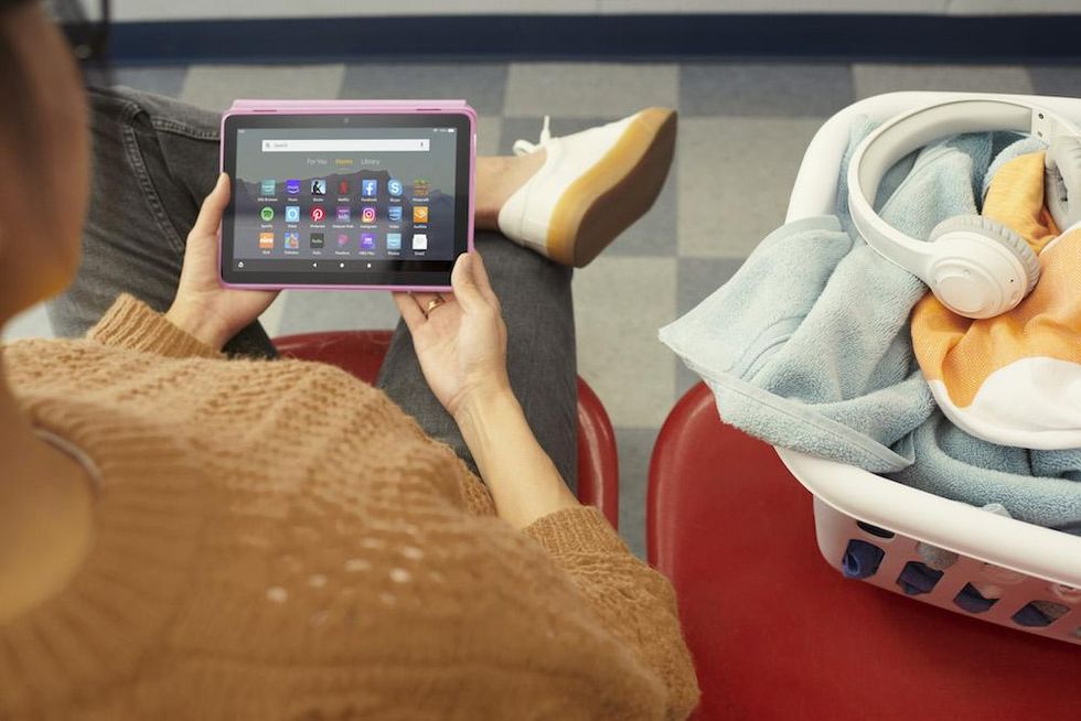 A photo of a woman sitting down using All-New Amazon Fire HD 8 Tablet