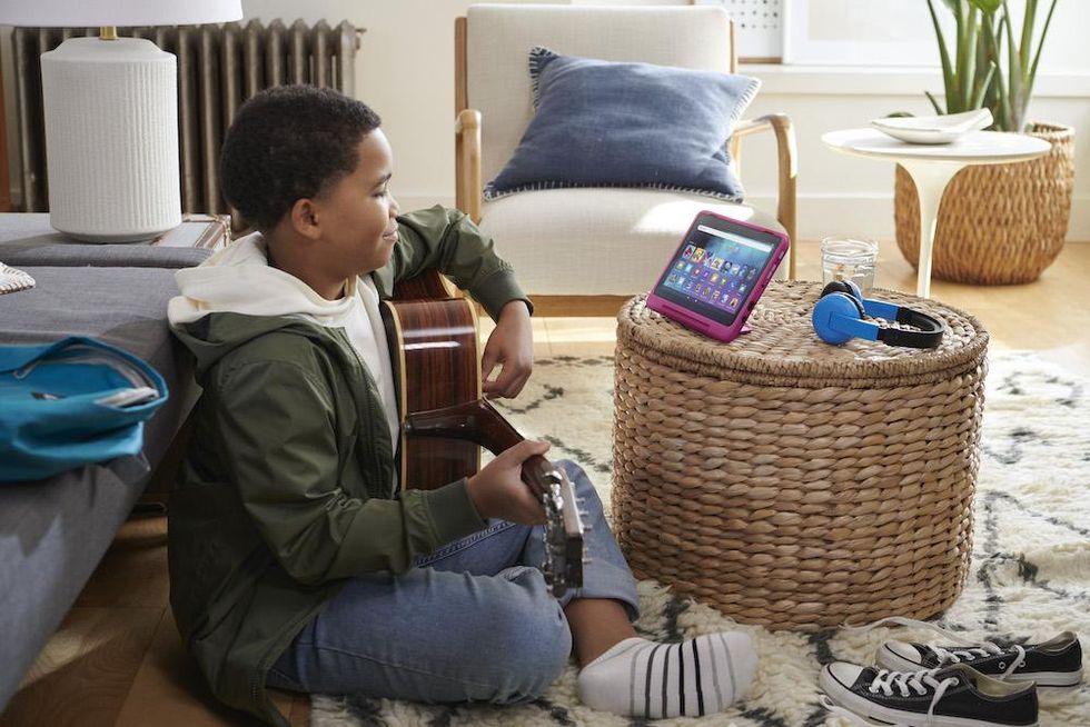 photo of a boy playing guitar and watching lessons on his Amazon Fire HD 8 Kids Pro tablet