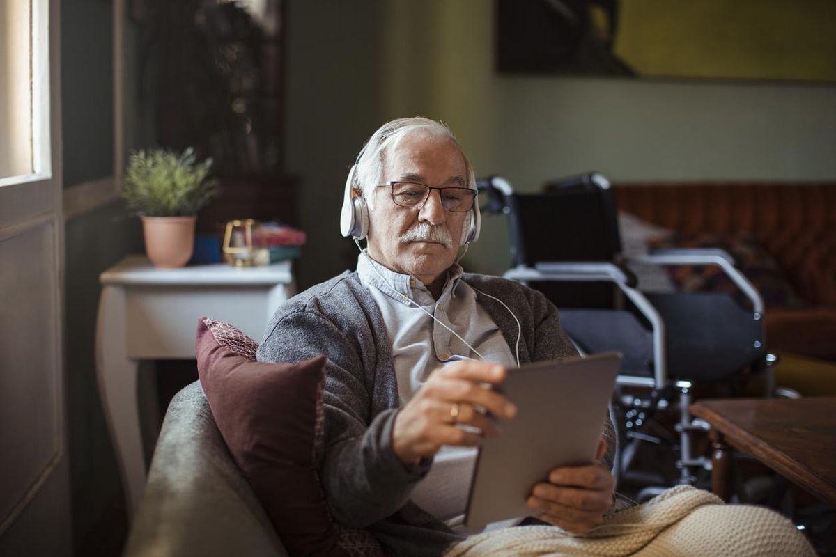 a senior man using a tablet with Tap to Alexa on it