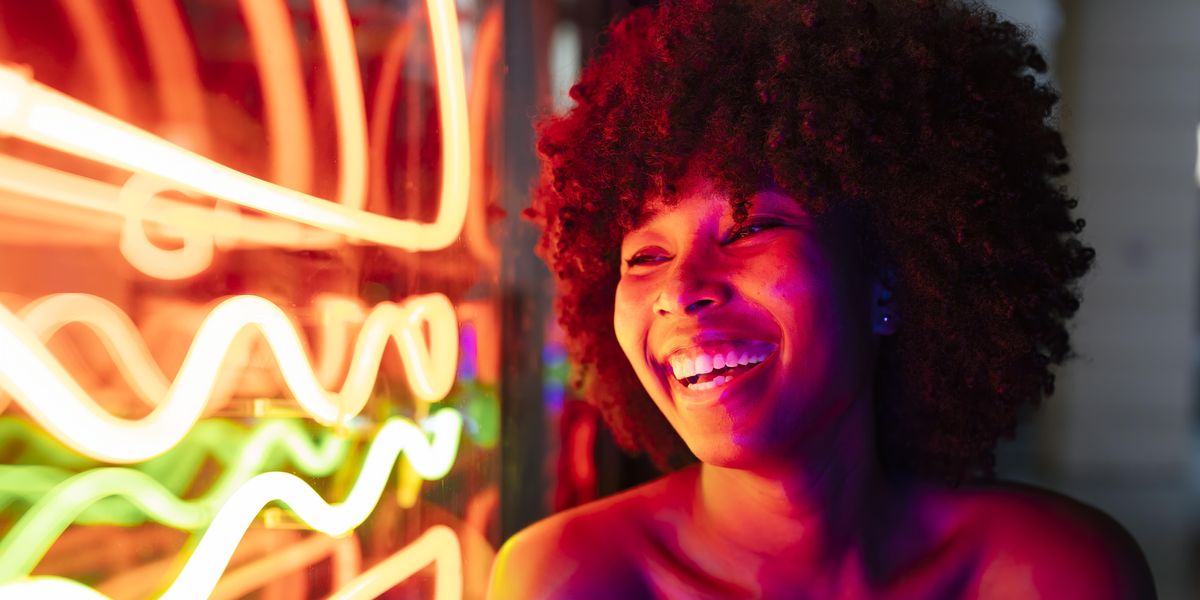 Black woman with an afro and tube top laughing