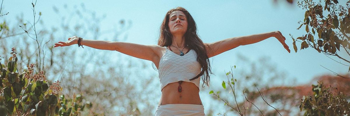 front view of a woman holding her arms out to the sky