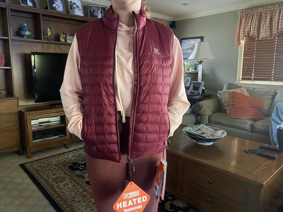 a photo of a woman wearing a smart vest with Fieldsheer's Mobile Warming technology built-in