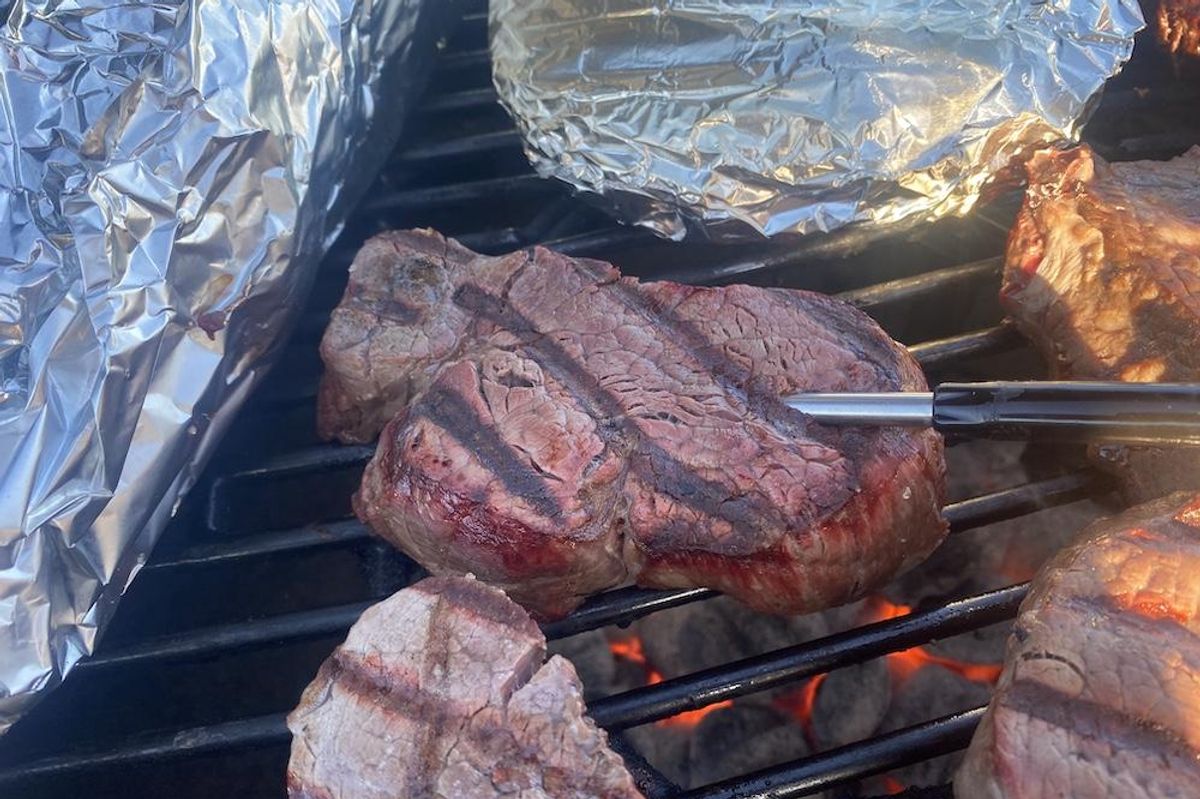 a photo of MeatStick inserted in a steak on the grill