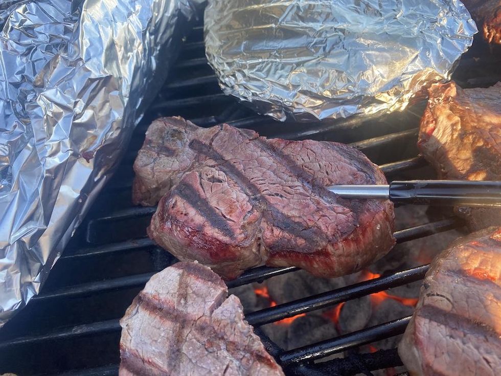 a photo of MeatStick inserted in a steak on the grill