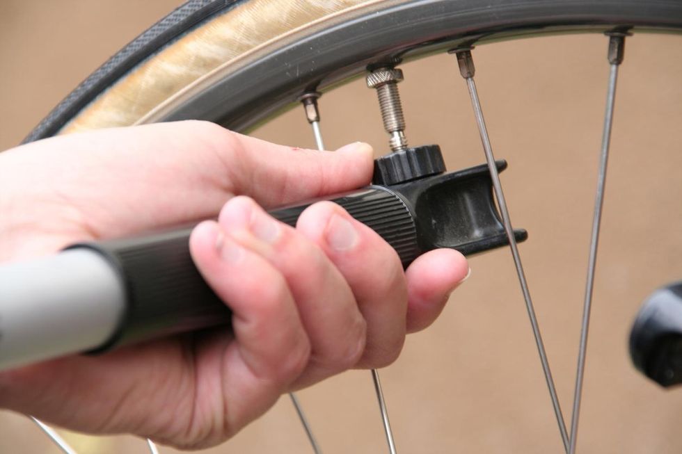 a photo of a portable bike pump filling a tire with air