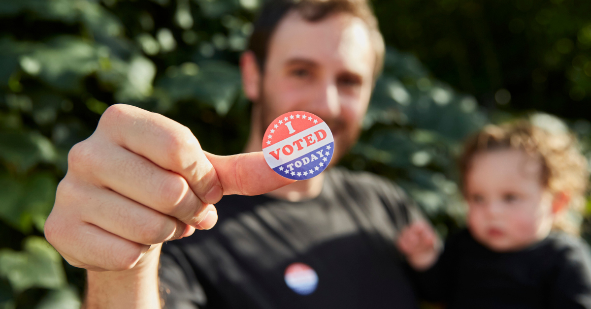 man holding child with I Voted sticker