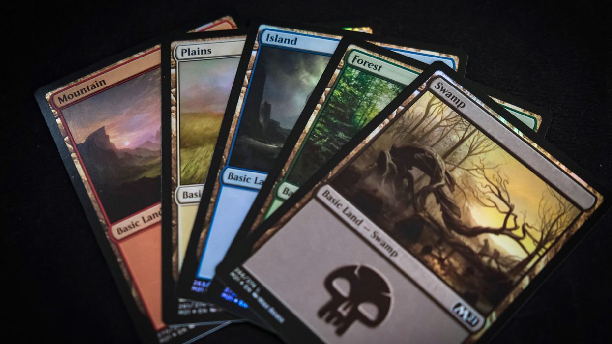 5 Magic the Gathering land cards fanned out on a black background