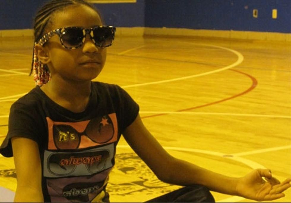 Child wearing sunglasses meditates