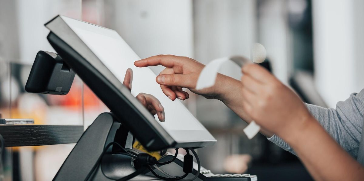 Hand holding a receipt and using a tablet