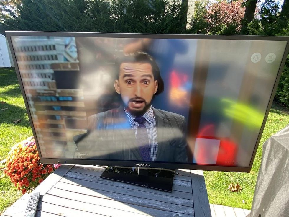 a photo of Aurora TV with glare from our garage