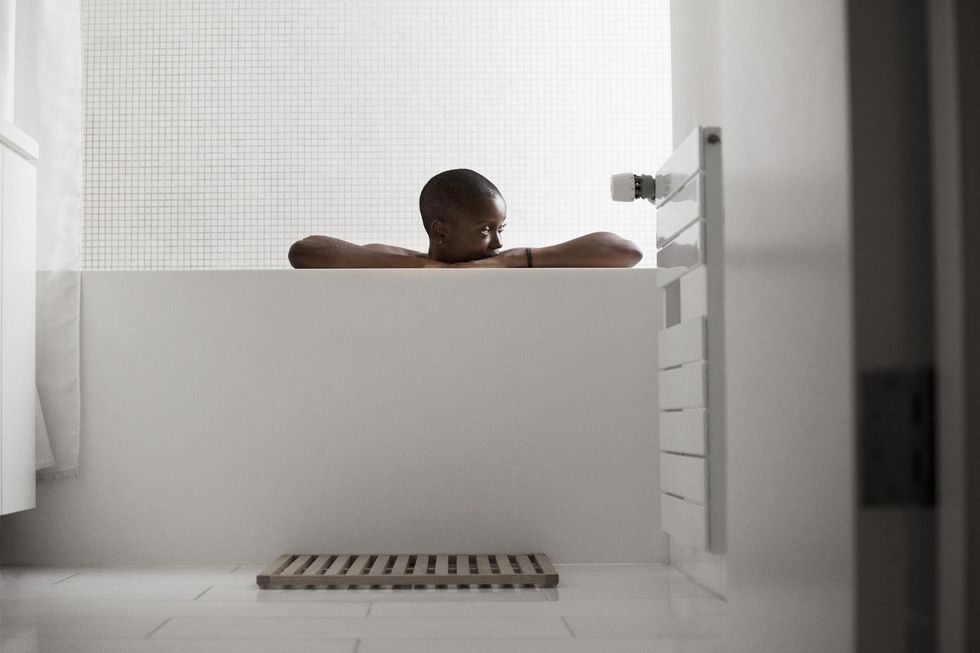 Black woman relaxing in bathtub