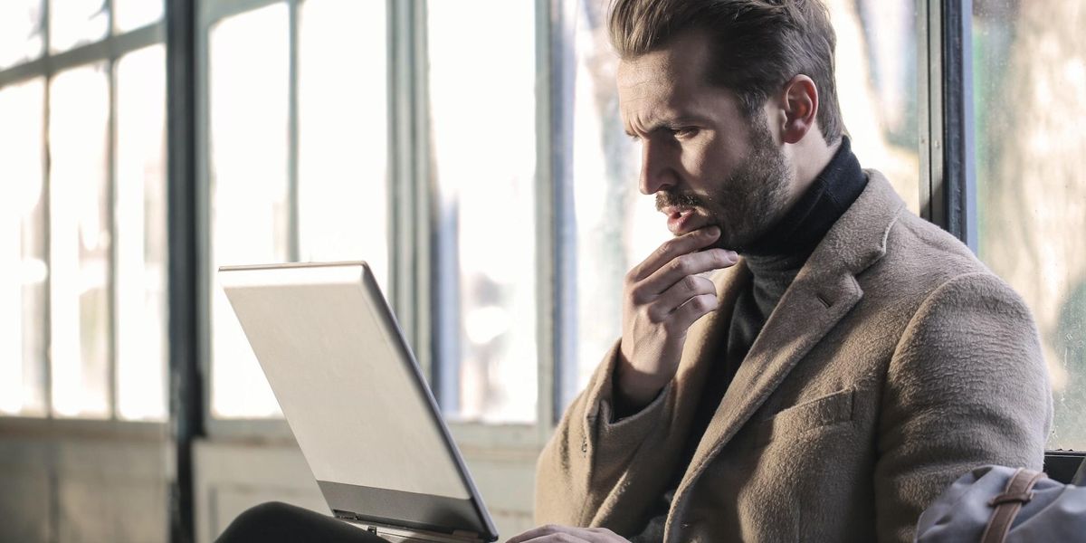 A man is on a computer with a confused face