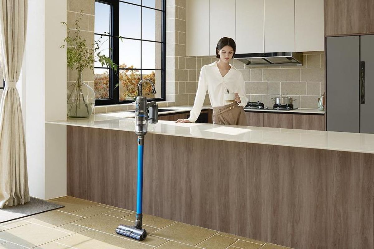 a photo with Puppyoo T12 Pure Cordless Vacuum Cleaner in a kitchen with a woman behind the counter