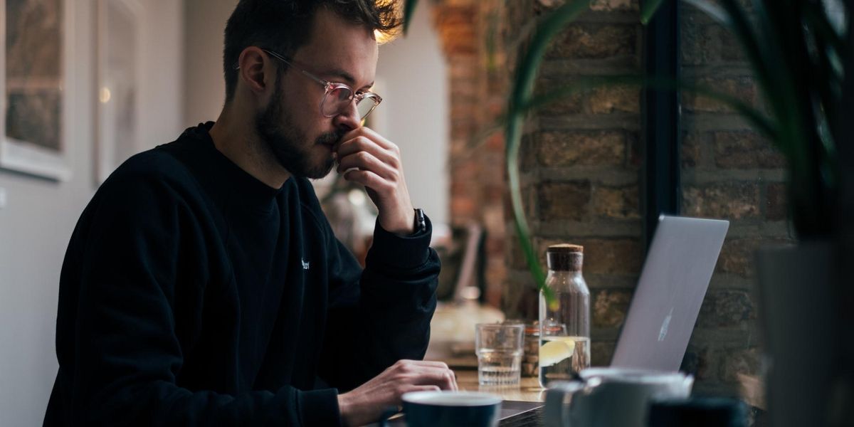 A man looking concerned reads from his laptop