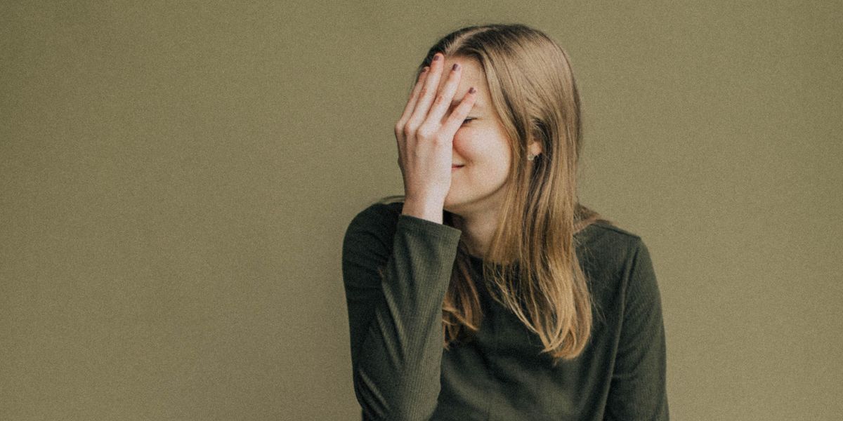 Woman covering her face in embarrassment