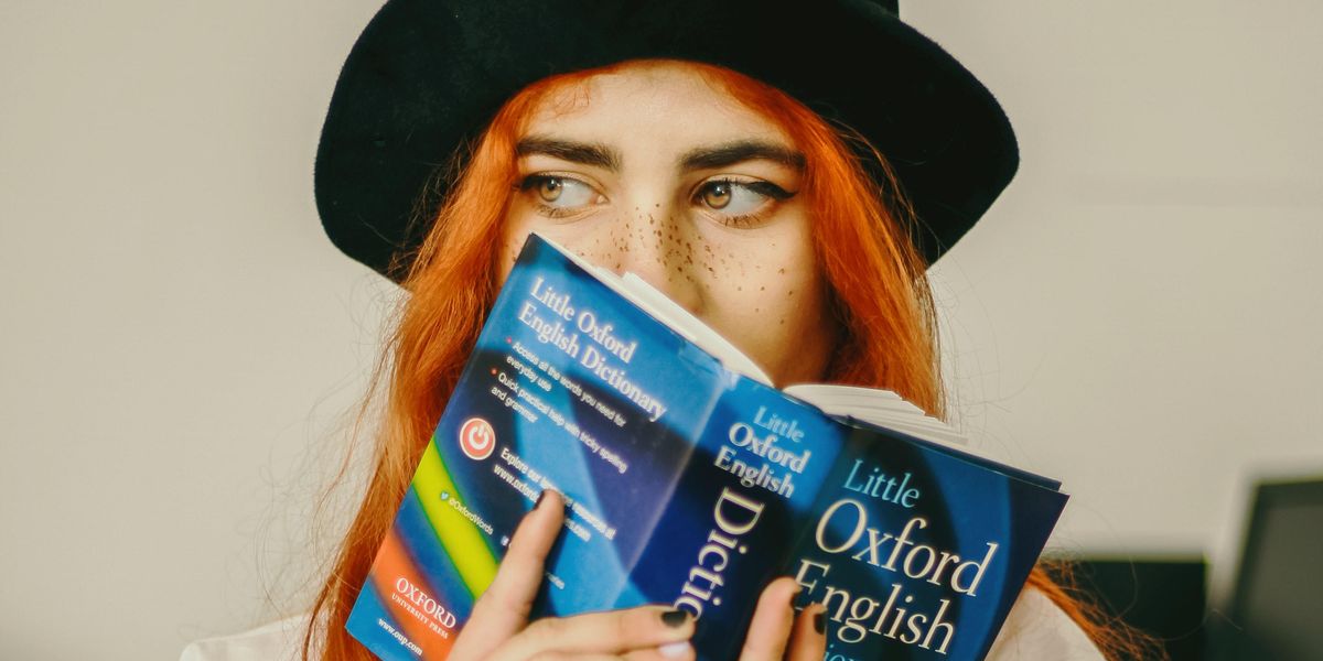 Young woman considering Oxford English Dictionary