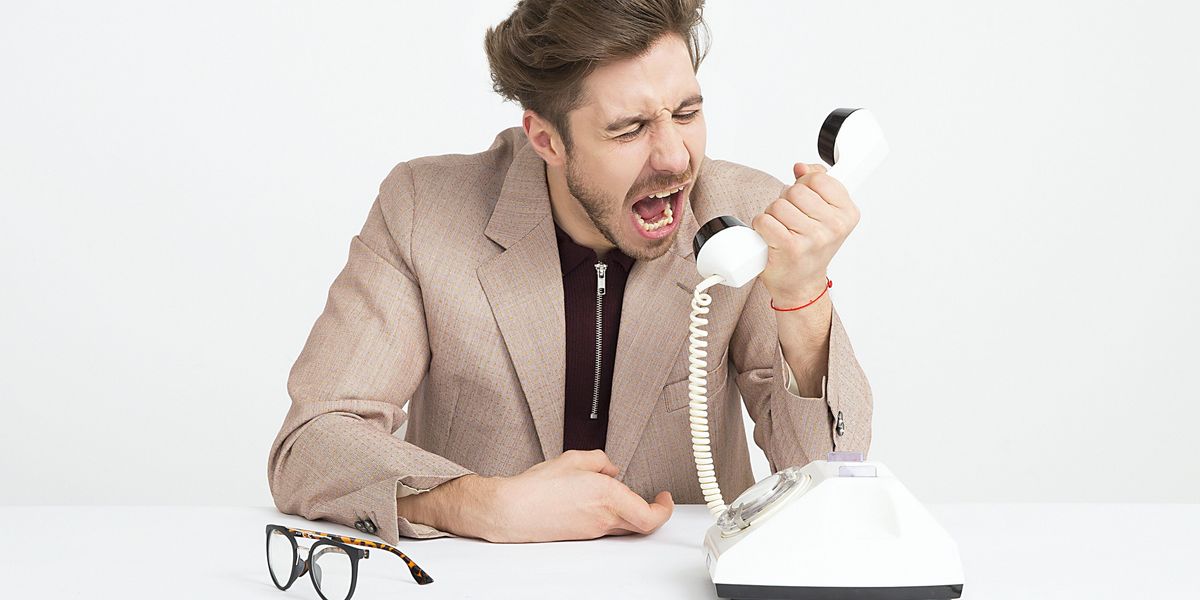 man holding telephone screaming