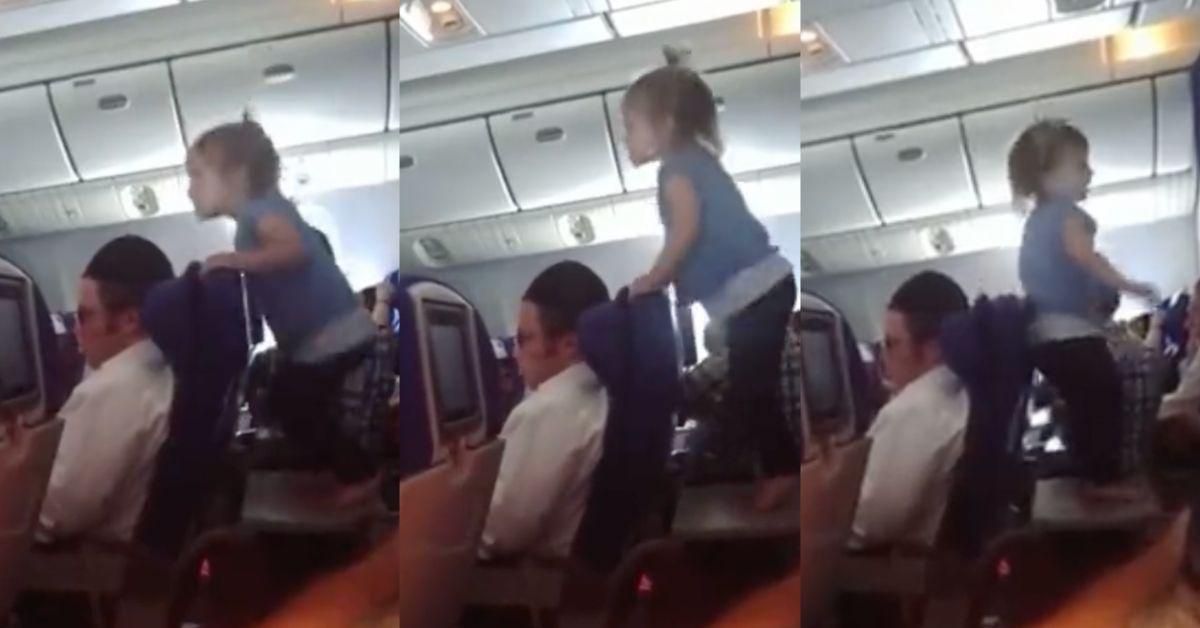 Toddler jumping on a tray table on an airplane.