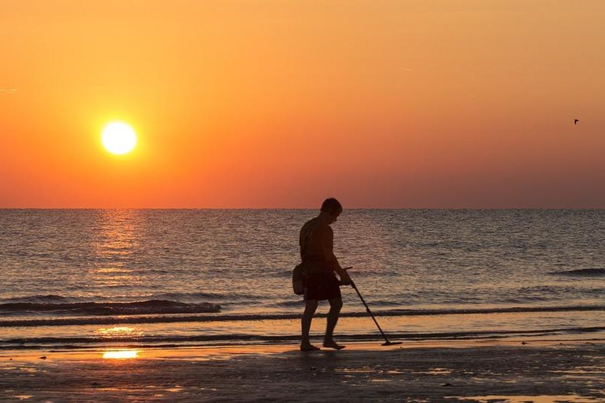 man with metal detector on beach