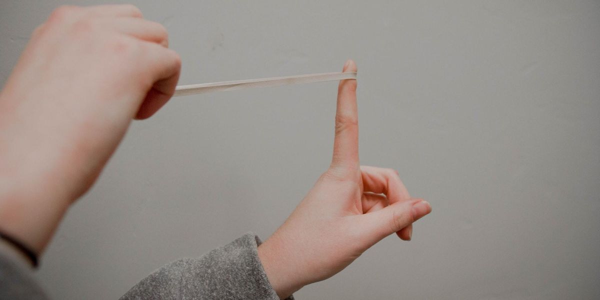 Two hands set up a makeshift slingshot