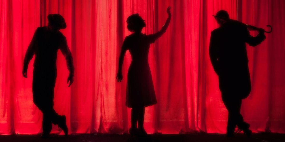 Three silhouettes of actors on a stage in front of a red curtain