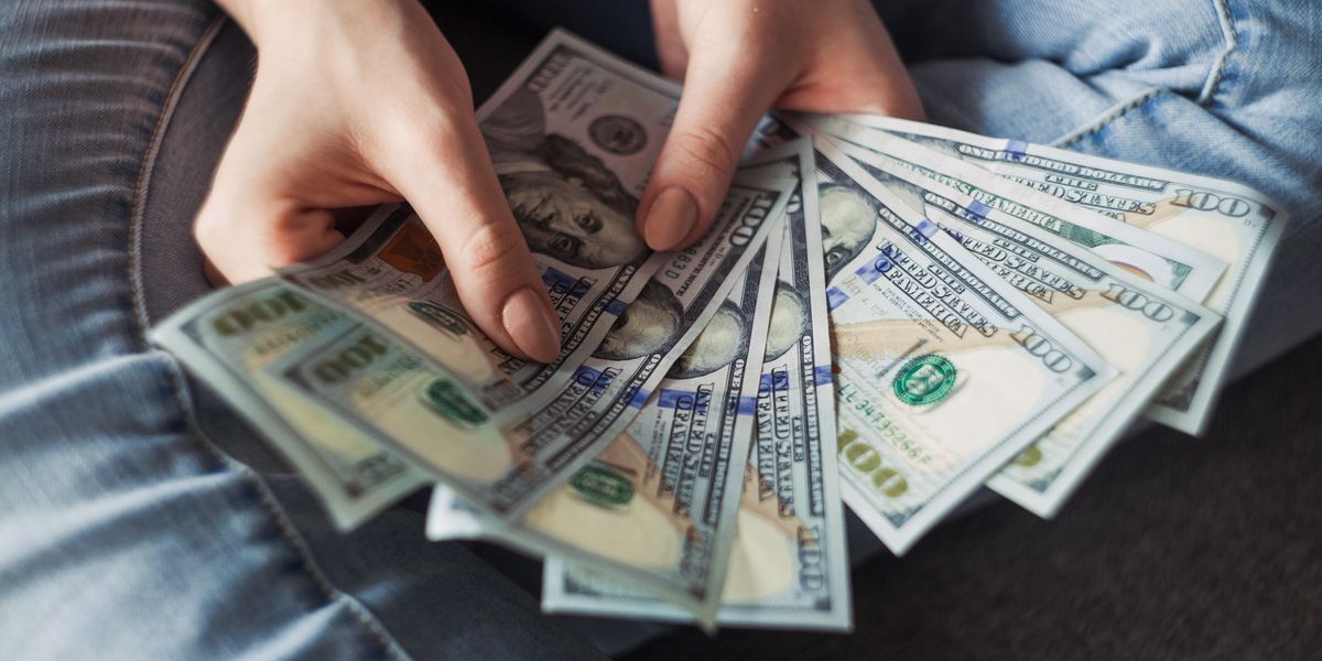 Woman holding multiple $100 bills