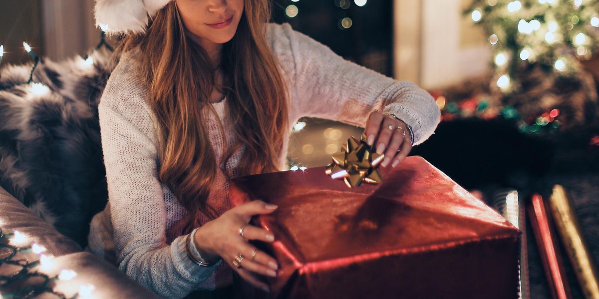 Woman somberly wrapping Christmas presents