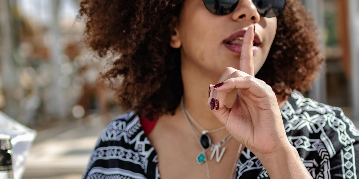 Woman putting finger to mouth in a shushing motion