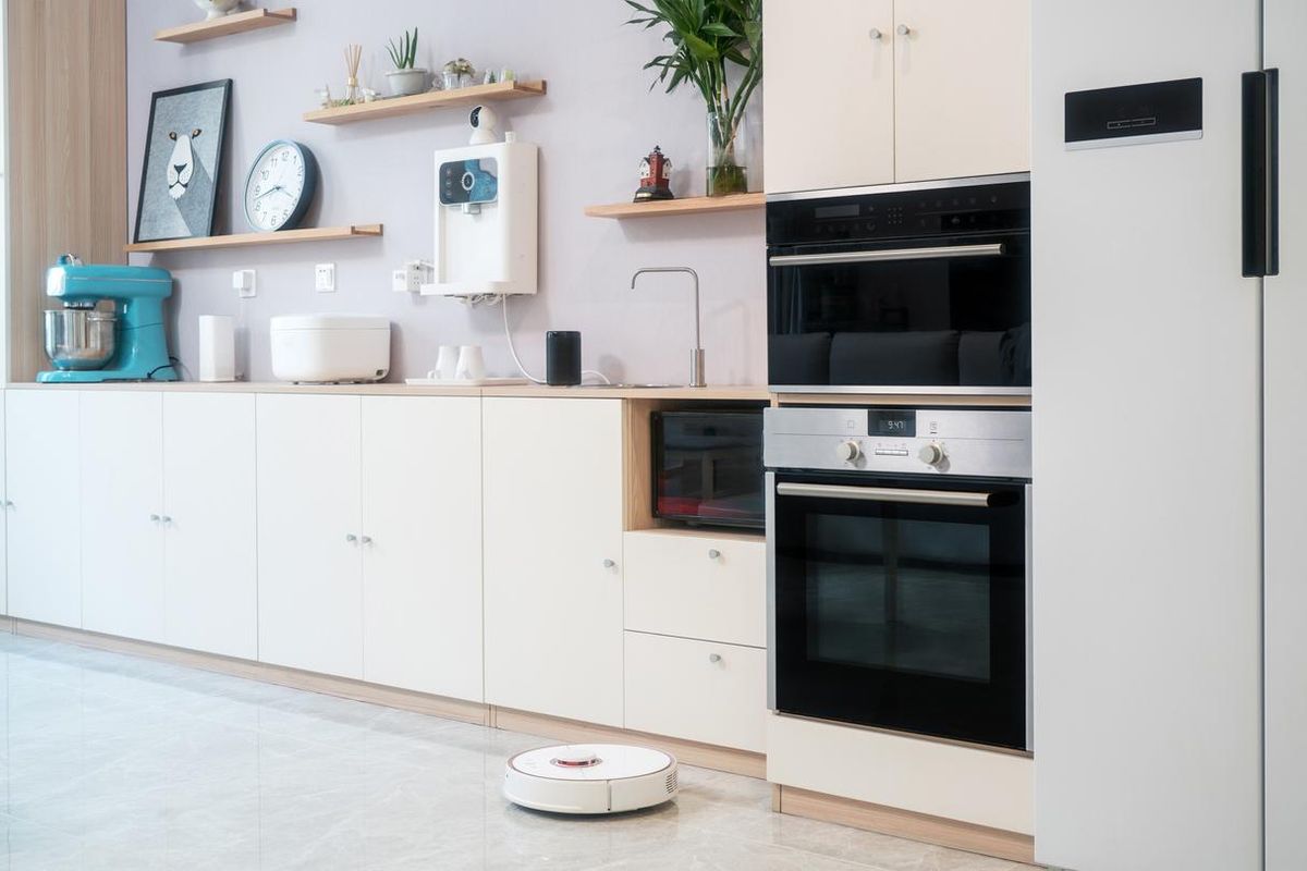 a photo of smart appliances in a kitchen with robot vacuum.