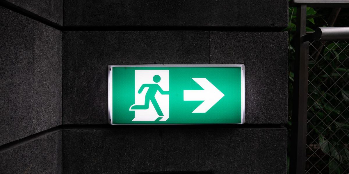 Exit sign of, with a person running away