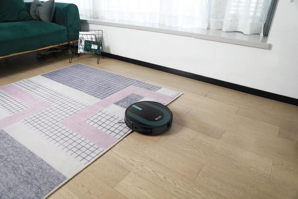 a photo of Proscenic 850T robot vacuum vacuuming a floor and carpet