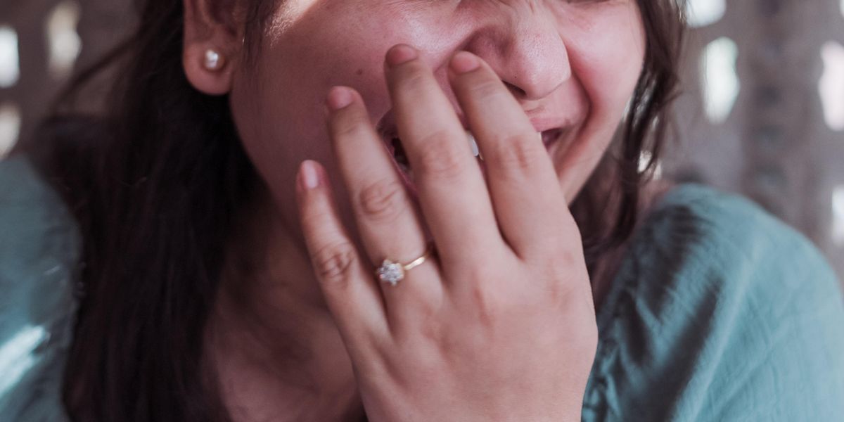 Woman covering her mouth to hide a laugh