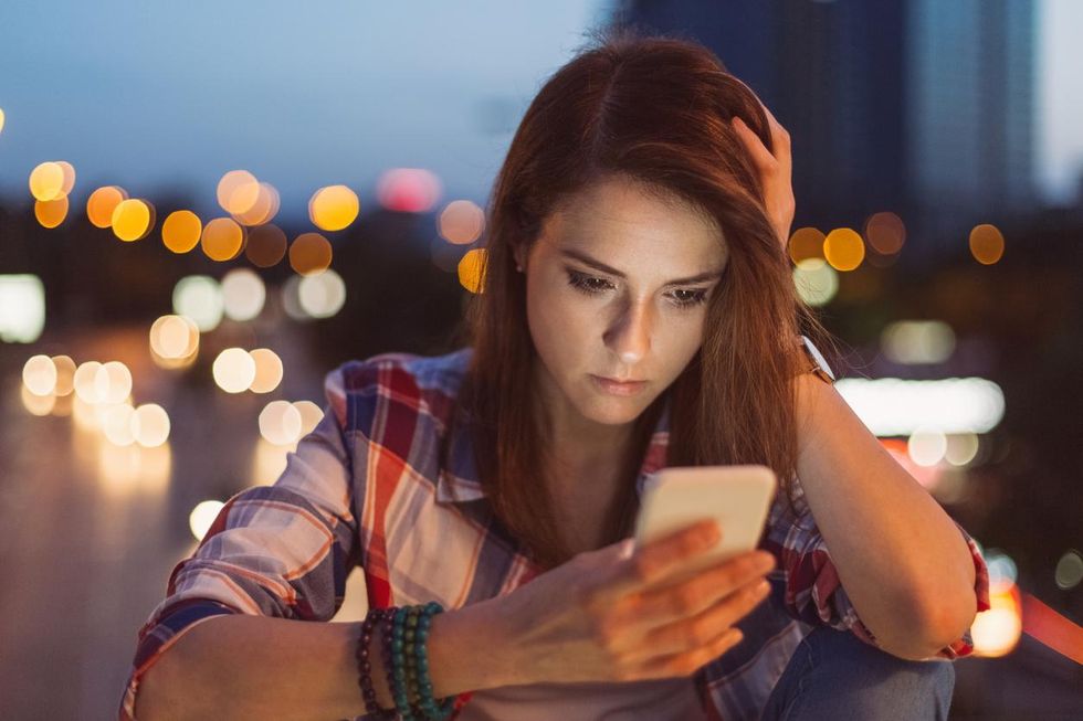 a photo of a woman on her smartphone depressed