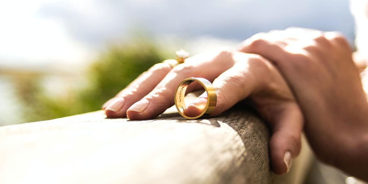 A woman's hands, with a wedding ring off the finger