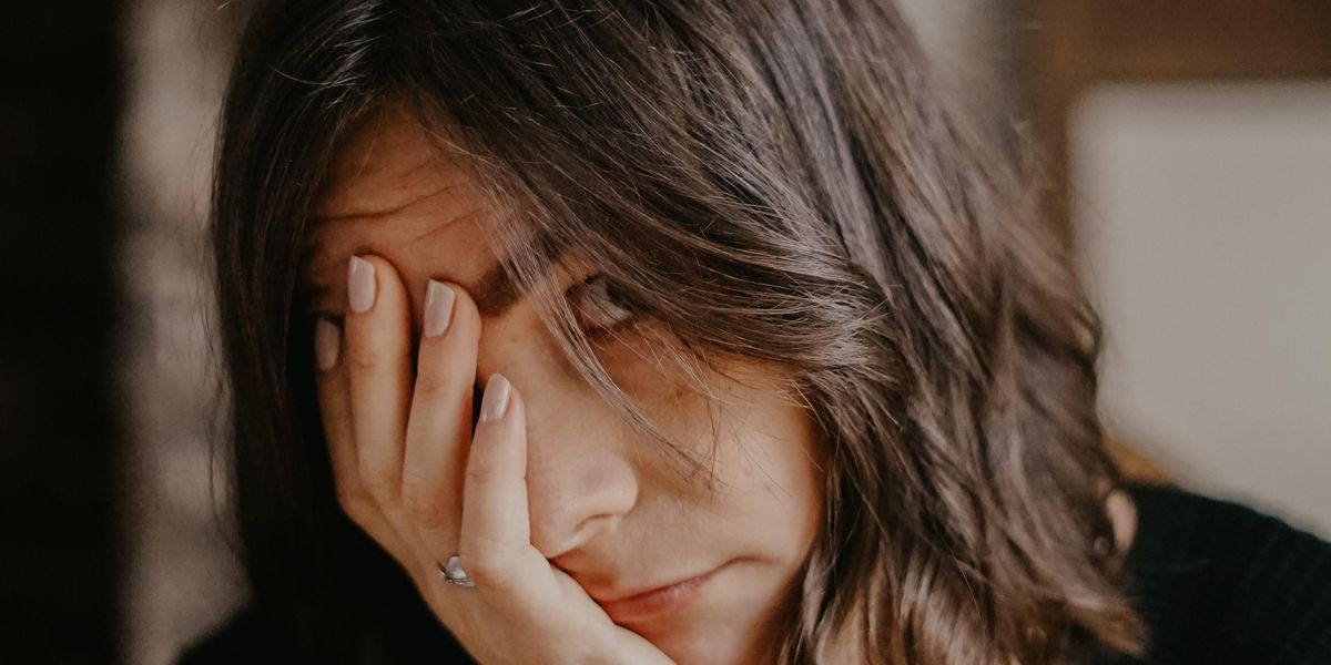 Woman holding head in her hands